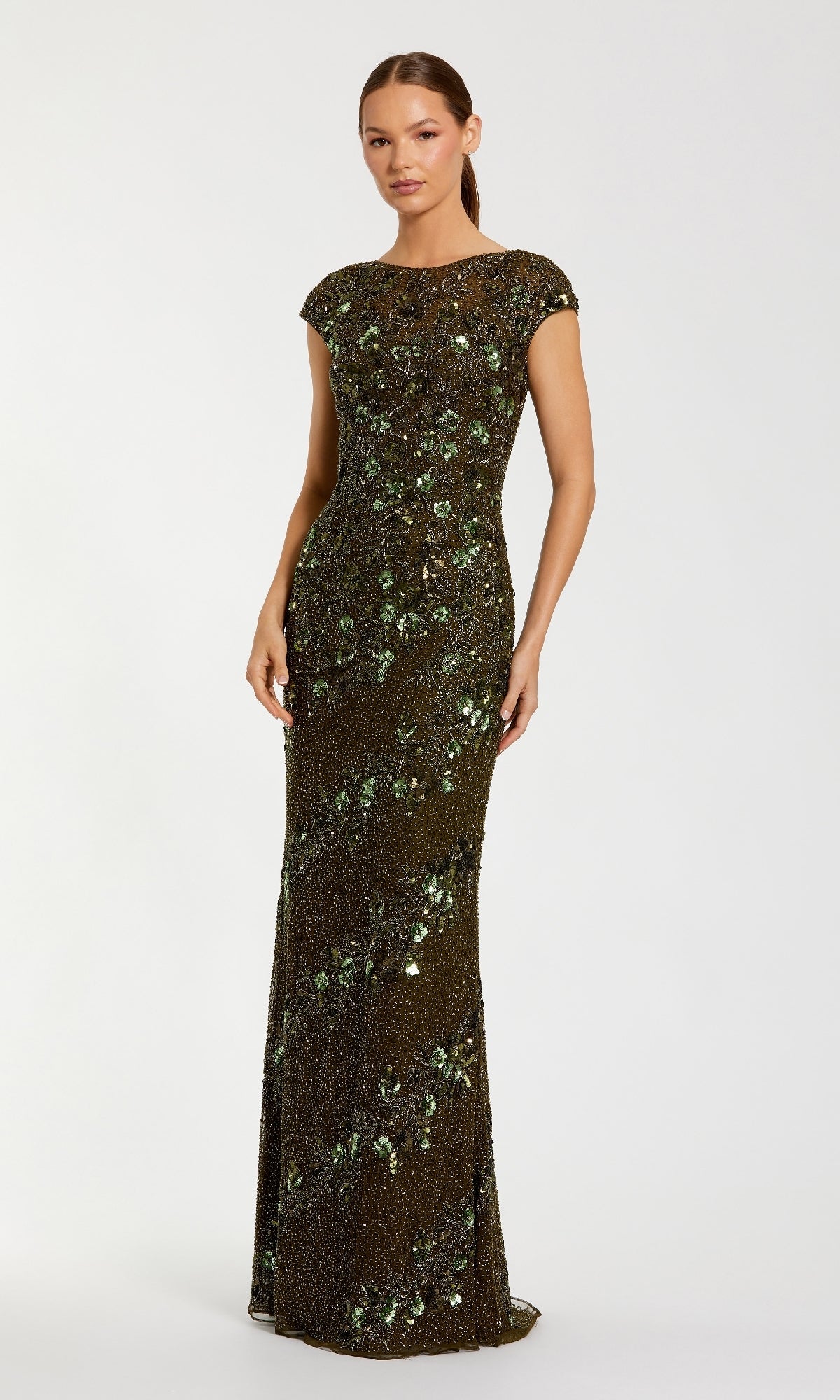 A woman wears the Mac Duggal 5500 Beaded Long Formal Dress, a floor-length evening gown with cap sleeves, a high neckline, and green and gold sequin embellishments, set against a plain background.